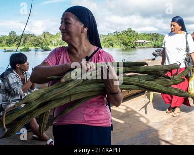 Amazonas, Peru - 03. Dez 2018: Lifestyle. Einheimische Frau, die auf der Fähre von Santa Rosa nach Iquit Obst verkauft (guama, Guaba, Pepeto, paterna oder inga) Stockfoto