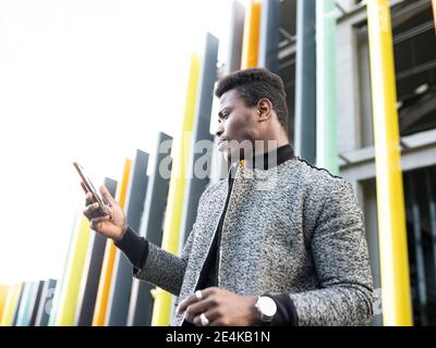 Portrait von eleganten jungen Mann mit Telefon Stockfoto