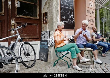 Touristen mit Elektrofahrrad trinken Kaffee, während sie in der Altstadt von Dresden sitzen, Deutschland Stockfoto