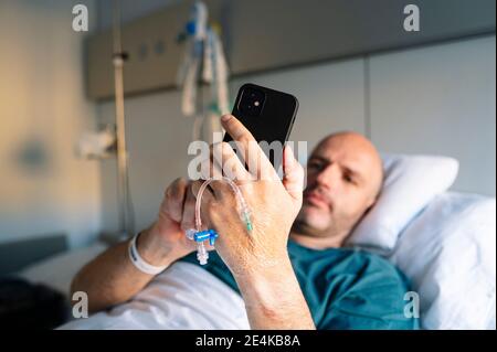 Lächelnder Oberarzt hält Tagebuch im Heimbüro Stockfoto