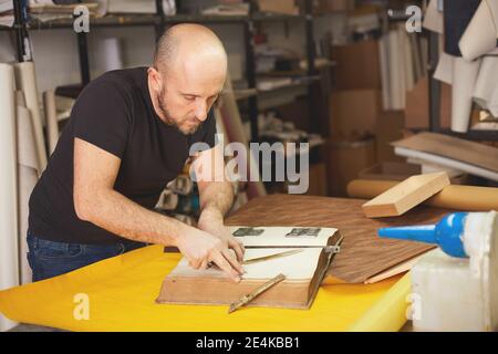 Buchbinder stellt altes Buch in Handwerkswerkstatt wieder her Stockfoto