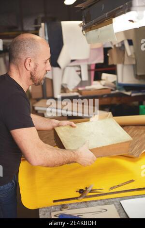 Buchbinder stellt altes Buch in Handwerkswerkstatt wieder her Stockfoto