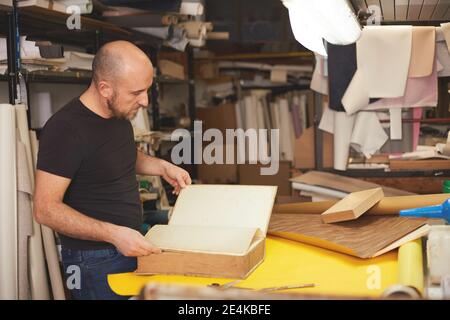 Buchbinder stellt altes Buch in Handwerkswerkstatt wieder her Stockfoto