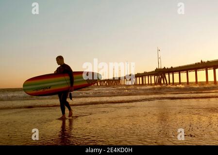 Surfer Walking mit Surfbrett. Sonnenuntergang am Venice Beach, Los Angeles, Kalifornien, USA. August 2019 Stockfoto