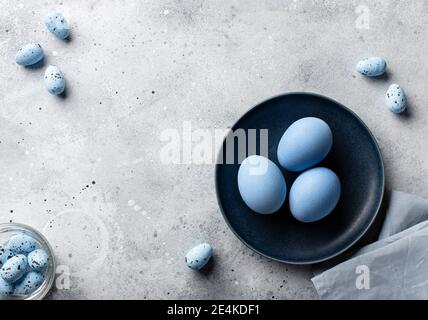 Osterhintergrund mit blauen Eiern in blauer Platte Stockfoto