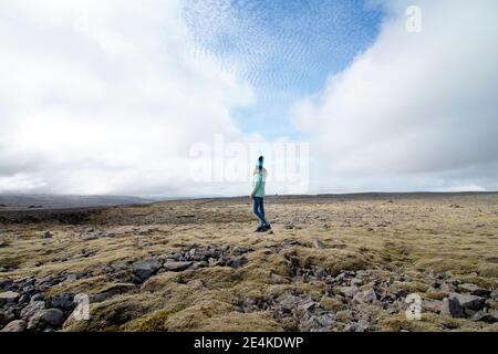 Mädchen schaut weg, während sie gegen den Himmel steht Stockfoto