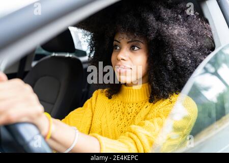 Junge Frau konzentriert sich beim Autofahren Stockfoto