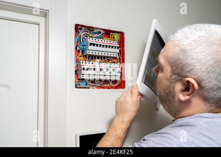 Stromverteilerkasten. Sicherungskasten. Mann, der Elektroarbeiten macht Stockfoto