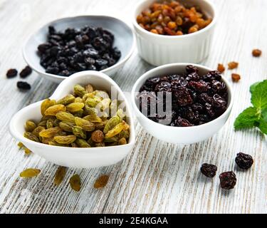 Sammlung verschiedener Rosinen auf weißem Holzgrund Stockfoto