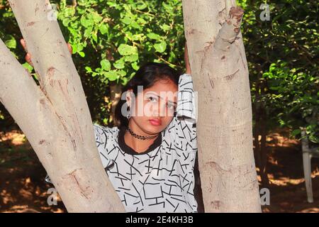 Eine schöne indische Hindu-Frau, die in einem Garten steht und einen Baum hält, hindu-Frau Gesicht Nahaufnahme Porträt, indien Stockfoto