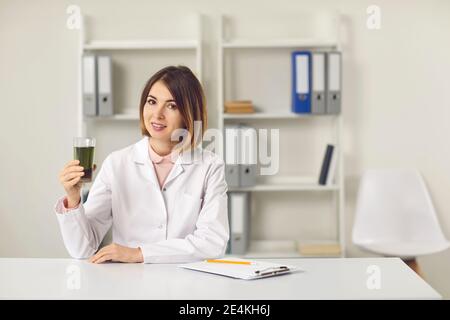 Junge Frau Ernährungswissenschaftlerin hält Glas von grünem Chlorophyll Spirulina trinken Stockfoto