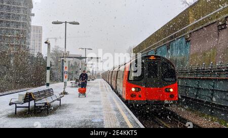 TFL-Arbeiter beeilte sich, während es am 24th. Januar 2021 schneit, auf dem Bahnsteig der Colindale U-Bahn-Station Spaltsalz zu verwenden. Transport für London sind auf schlechtes Wetter nicht vorbereitet auf die Londoner U-Bahn-Netz depite met Office Wetterwarnungen, die für starken Schneefall vorhanden sind. Colindale, London. Wetter in Großbritannien. Stockfoto