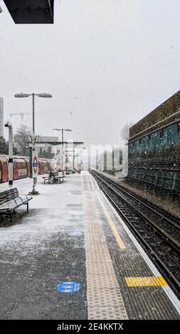 TFL-Arbeiter beeilte sich, während es am 24th. Januar 2021 schneit, auf dem Bahnsteig der Colindale U-Bahn-Station Spaltsalz zu verwenden. Der Transport nach London ist auf schlechtes Wetter im Londoner U-Bahnnetz nicht vorbereitet, obwohl die Wetterwarnungen von Met Office bei starkem Schneefall vorliegen. Colindale, London. Wetter in Großbritannien. Stockfoto