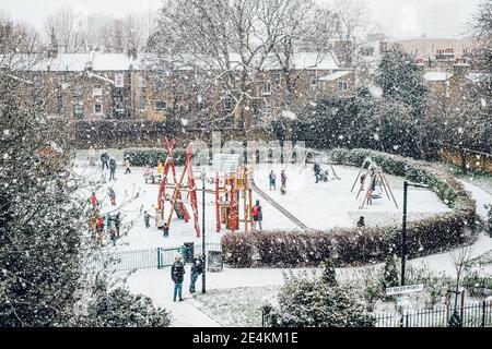 Camberwell, London, Großbritannien. Januar 2021. Kinder genießen den Schnee auf dem Spielplatz des Brunswick Park, Camberwell. Der erste Schnee in London seit Jahren bringt Kinder und Erwachsene in den Genuss einer Ruhepause von der UK Lockdown. Kredit: Tom Leighton/Alamy Live Nachrichten Stockfoto