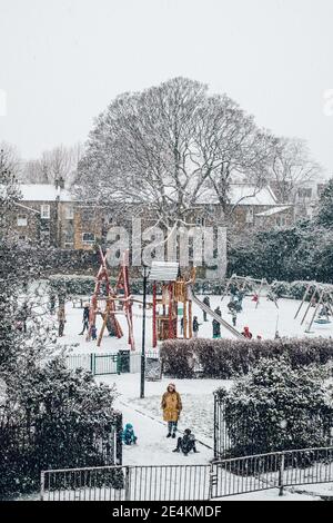 Camberwell, London, Großbritannien. Januar 2021. Kinder genießen den Schnee auf dem Spielplatz des Brunswick Park, Camberwell. Der erste Schnee in London seit Jahren bringt Kinder und Erwachsene in den Genuss einer Ruhepause von der UK Lockdown. Kredit: Tom Leighton/Alamy Live Nachrichten Stockfoto