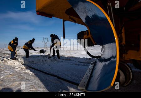 (210124) -- EMIN, 24. Januar 2021 (Xinhua) -- Arbeiter des Tiechanggou-Reparaturteams entfernen manuell schwer verhüllten Schnee auf Eisenbahngleisen im windigen Maytas-Gebiet entlang der Karamay-Tacheng-Eisenbahn, in der Autonomen Region Xinjiang Uygur im Nordwesten Chinas, 21. Januar 2021. Maytas, genannt 'Hölle des Windes', ist ein wildes Gebiet, in dem die Karamay-Tacheng-Eisenbahnstrecke in Xinjiang verläuft. Es ist auch ein Ort, wo die Tiechanggou Reparatur-Team unter der China Railway Urumqi Bureau Group Co., Ltd ist auf der Uhr 24 Stunden am Tag, um den sicheren Betrieb aller Züge vorbei zu gewährleisten.Maytas ist ein Schneesturm-Pron Stockfoto