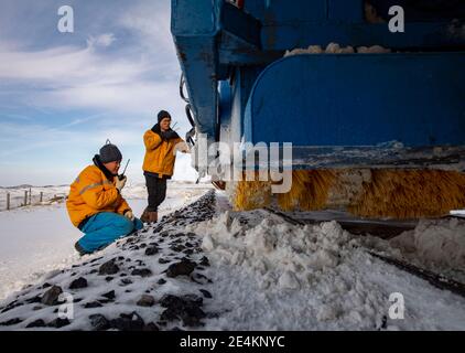 (210124) -- EMIN, 24. Januar 2021 (Xinhua) -- Yang Shenghui (R) und sein Arbeitskollege des Tiechanggou-Reparaturteams überprüfen die Schneeräumgeräte einer Eisenbahngleisschneemühlmaschine in Emin, im Nordwesten Chinas Autonome Region Xinjiang Uygur, 21. Januar 2021. Maytas, genannt 'Hölle des Windes', ist ein wildes Gebiet, in dem die Karamay-Tacheng-Eisenbahnstrecke in Xinjiang verläuft. Es ist auch ein Ort, wo die Tiechanggou Reparatur-Team unter der China Railway Urumqi Bureau Group Co., Ltd ist auf der Uhr 24 Stunden am Tag, um den sicheren Betrieb aller Züge vorbei zu gewährleisten.Maytas ist ein Schneesturm-Bereich anfällig Stockfoto