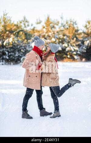 Mann und Frau in der Liebe küssen über weißen Winterwald Stockfoto
