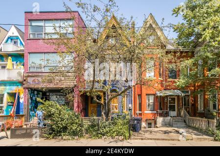 Toronto, Canada - 26/07/2019 - Farbiges Haus in einer Linie in Kensington Market, Bäume auf den Gehwegen Stockfoto