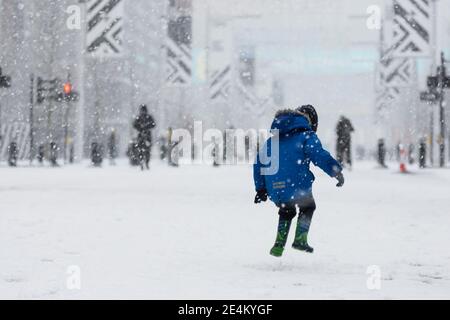 UK Wetter, Wembley Park, UK. 24. Januar 2021.EIN kleiner Junge springt vor Freude im Schnee auf Olympic Way als Sonntagmorgen London bringt es den ersten Schneefall des Jahres. Amanda Rose/Alamy Live News Stockfoto