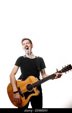 Gitarrist spielt und singt laut auf isoliertem weißem Hintergrund Stockfoto