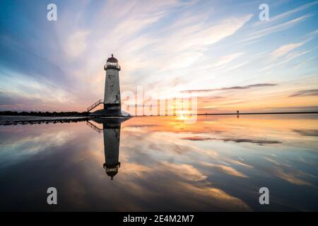 Leuchtturm steht im Pool von Wasser atemberaubende Sonnenuntergang Sonnenaufgangsreflexion Spiegelt sich in Wasser Meer Schritte Gebäude Nord Wales Küste Sandstrand Stockfoto