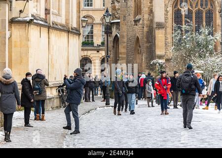 Oxford, Oxfordshire, Großbritannien. Januar 2021, 24. Die Menschenmassen wimmern auf dem Radcliffe-Platz. Mehrere Zentimeter Schnee fallen in Oxford. Das Stauben von Schnee über die historischen Gebäude von Oxford zieht Massen trotz der Sperre an, Credit: Sidney Bruere/Alamy Live News Stockfoto