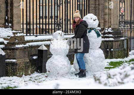 Oxford, Oxfordshire, Großbritannien. Januar 2021, 24. Ein Mädchen baut Schneemänner vor den Toren der Prüfungsschulen in der Merton Street. Mehrere Zentimeter Schnee fallen in Oxford. Das Stauben von Schnee über die historischen Gebäude von Oxford zieht Massen trotz der Sperre an, Credit: Sidney Bruere/Alamy Live News Stockfoto