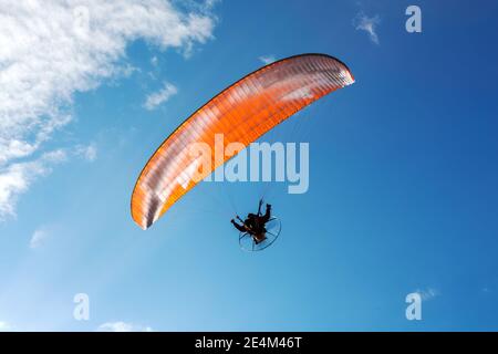 Fallschirm des Fallschirms am Himmel. Fliegen mit dem Paramotor (Gleitschirm) am blauen Himmel Stockfoto