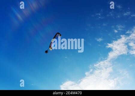 Fallschirm des Fallschirms am Himmel. Fliegen mit dem Paramotor (Gleitschirm) am blauen Himmel Stockfoto