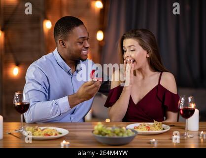 Heiratsantrag. Romantische Black Boyfriend Schlägt Freundin Zu Heiraten Ihn Im Restaurant Stockfoto