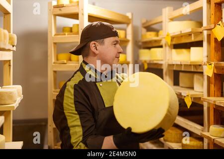 Mitarbeiter einer privaten Käsefabrik im Geschäft während Der Produktionsprozess Stockfoto