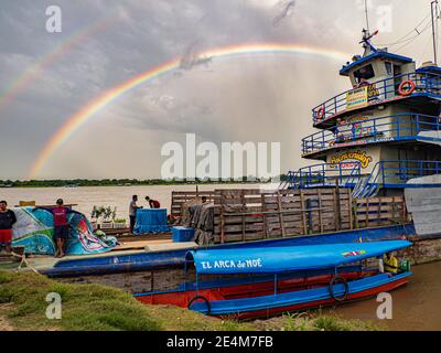 Amazonas, Peru - 07. Dezember 2019: Blick auf das langsame Boot 'Maria Fernanda' und Regenbogen im kleinen Hafen am Amazonas. Amazonien. Südamerika Stockfoto