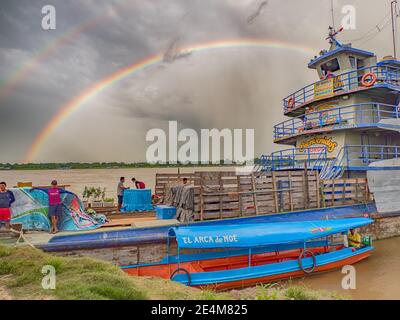 Amazonas, Peru - 07. Dezember 2019: Blick auf das langsame Boot 'Maria Fernanda' und Regenbogen im kleinen Hafen am Amazonas. Amazonien. Südamerika Stockfoto