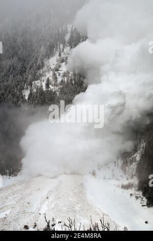 Schneelawine donnert einen steilen Berghang in den schweizer alpen hinunter. Stockfoto