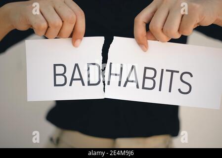 Frau hält eine zerrissene Papierhände mit den Worten Bad Habits , Selbstentwicklung Konzept Stockfoto