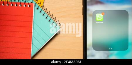 Rom, Italien, 24. Januar 2021. Einige Notizblöcke und ein Smartphone mit der Whatsapp App auf einem Schreibtisch. Stockfoto