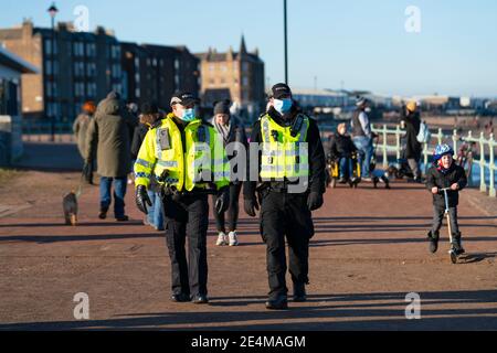 Portobello, Schottland, Großbritannien. 24. Januar 2021. Große Anzahl von Mitgliedern der Öffentlichkeit am Portobello Strand und Promenade am sonnigen Sonntagnachmittag während der Sperre. Während die meisten Menschen beobachtet soziale distanzierende Gruppen von Menschen in einigen der Cafés mit Essen und Getränken zum Mitnehmen gebildet. Polizeipatrouillen sprachen mit den öffentlichen Sitzen und in Gruppen in Cafés, um sie zu bitten, weiter zu gehen. Iain Masterton/Alamy Live News Stockfoto