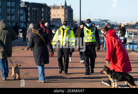 Portobello, Schottland, Großbritannien. 24. Januar 2021. Große Anzahl von Mitgliedern der Öffentlichkeit am Portobello Strand und Promenade am sonnigen Sonntagnachmittag während der Sperre. Während die meisten Menschen beobachtet soziale distanzierende Gruppen von Menschen in einigen der Cafés mit Essen und Getränken zum Mitnehmen gebildet. Polizeipatrouillen sprachen mit den öffentlichen Sitzen und in Gruppen in Cafés, um sie zu bitten, weiter zu gehen. Iain Masterton/Alamy Live News Stockfoto