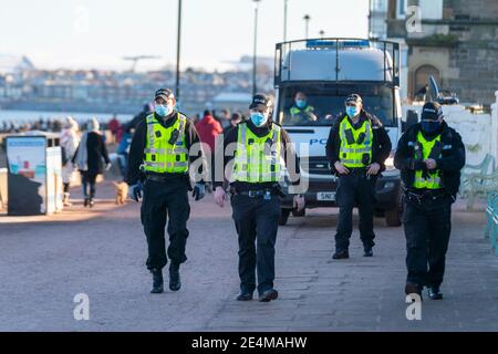 Portobello, Schottland, Großbritannien. 24. Januar 2021. Große Anzahl von Mitgliedern der Öffentlichkeit am Portobello Strand und Promenade am sonnigen Sonntagnachmittag während der Sperre. Während die meisten Menschen beobachtet soziale distanzierende Gruppen von Menschen in einigen der Cafés mit Essen und Getränken zum Mitnehmen gebildet. Polizeipatrouillen sprachen mit den öffentlichen Sitzen und in Gruppen in Cafés, um sie zu bitten, weiter zu gehen. Iain Masterton/Alamy Live News Stockfoto