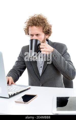 Porträt des nachdenklichen Geschäftsmann in Fliege und Jacke mit Laptop Und eine Tasse Kaffee halten Stockfoto