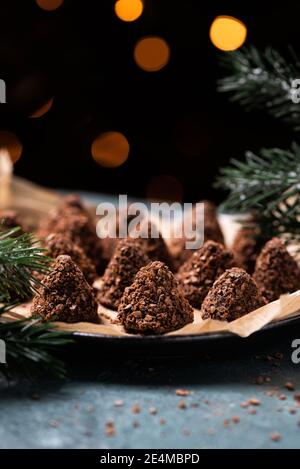 Trüffelschokolade-Bonbons mit verschiedenen Waffelbröseln. Süßes hausgemachtes Dessert auf einem Teller Stockfoto