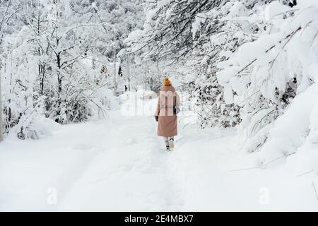 Rückansicht einer Frau, die im Schnee läuft Stockfoto