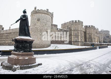 Windsor, Großbritannien. Januar 2021, 24. Der erste Schneefall des Winters liegt auf dem Boden vor Windsor Castle und rund um die Statue von Königin Victoria. Es wird erwartet, dass sich der Zauber des kalten Wetters bis Mittwoch fortsetzt. Kredit: Mark Kerrison/Alamy Live Nachrichten Stockfoto