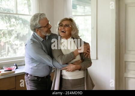 Überglücklich reifer Mann und Frau tanzen in der Küche, Spaß haben Stockfoto