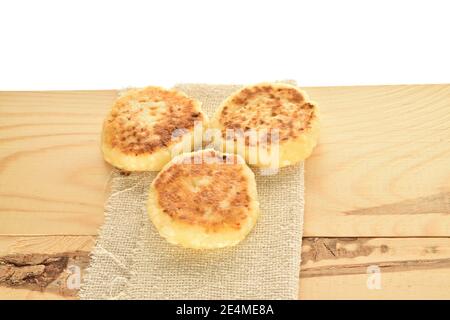 Ein paar ganze aromatisierte leckere Käse Pfannkuchen liegen auf einer Stoffserviette, die auf einer hölzernen Tischplatte liegt. Der Hintergrund ist weiß. Stockfoto