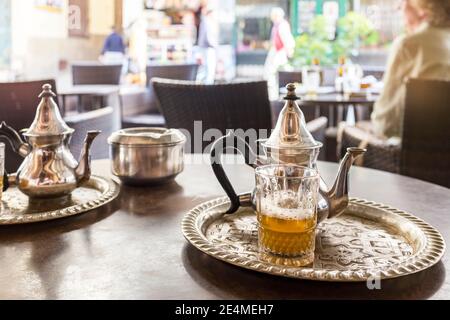 Topf und Glas Minztee auf einem Metalltablett in einem Café in Tanger, Marokko Stockfoto
