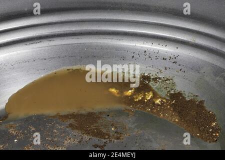 Goldnuggets in einer Metallgoldpfanne Stockfoto