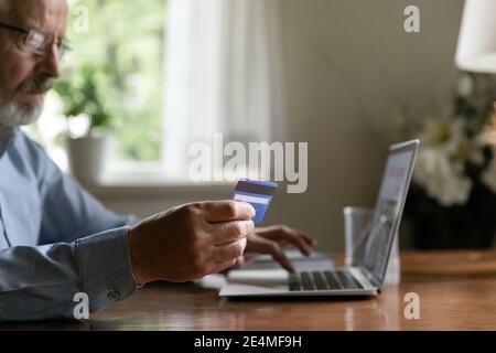 Nahaufnahme fokussierten reifen Mann machen sichere Internet-Zahlung Stockfoto