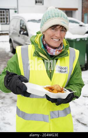 Bewdley, Großbritannien. Januar 2021. Alle Hände sind heute an Deck und helfen bei der Säuberung in Bewdley von Überschwemmungsschäden. Dieser Dame aus der örtlichen Hochwassergruppe wurde kostenloses warmes Essen angeboten, das den Bedürftigen serviert wird und aushilft. Gekocht und serviert von Khalsa Aid (Khalsa Aid International ist eine humanitäre Hilfsorganisation in Großbritannien, die Opfer von Naturkatastrophen und von Menschen verursachten Katastrophen unterstützt), die außerhalb des öffentlichen Hauses des Black Boy eingerichtet werden. Stockfoto